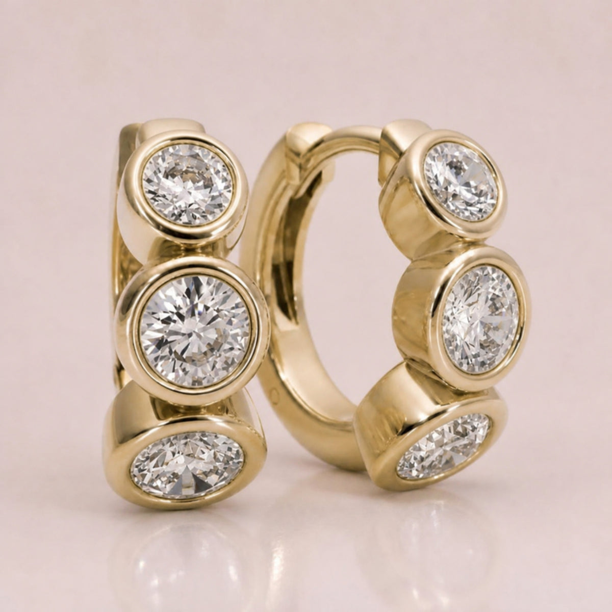 The Muse Bezel Huggies in yellow gold with fine bezel-set diamonds